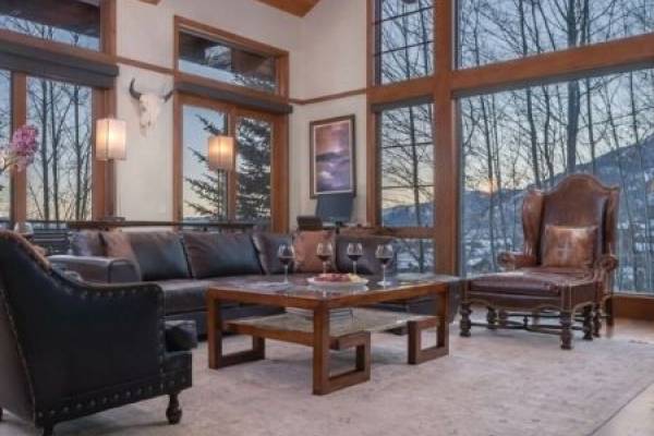 Beautiful mountain home living room, large window looking out onto winter mountain scene.