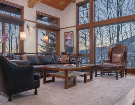 Beautiful mountain home living room, large window looking out onto winter mountain scene.